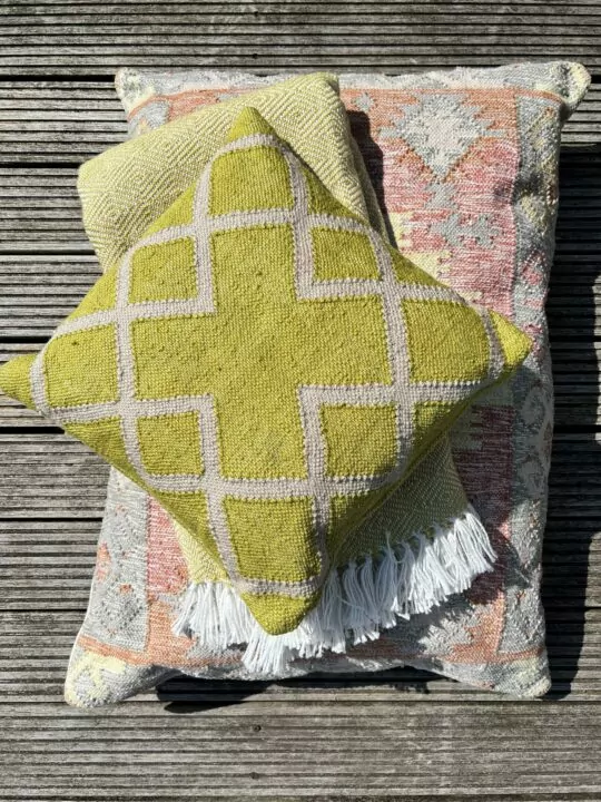Juno kussen geel op stapel met tarifa vloerkussen en gele deken
