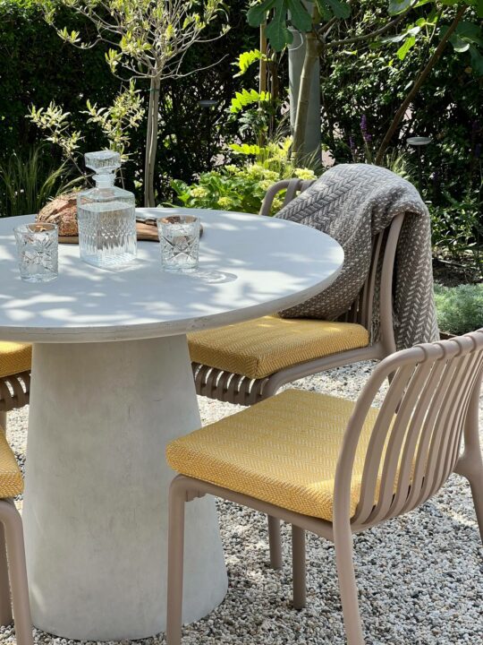 2 stoelen in een tuin met een geel zitkussen