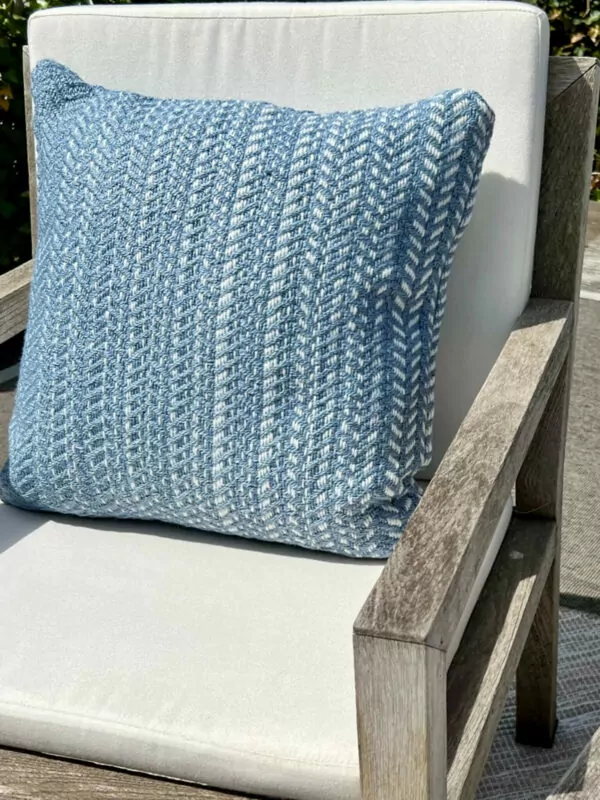 Close-up foto van luchtblauw kussen in tuinstoel met witte tuinstoel kussens