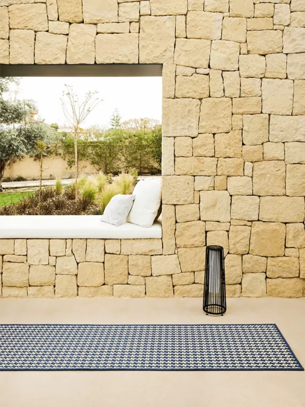 Buitenkleed met sisal look in 2 kleuren in beige met kobaltblauw op patio met windlicht