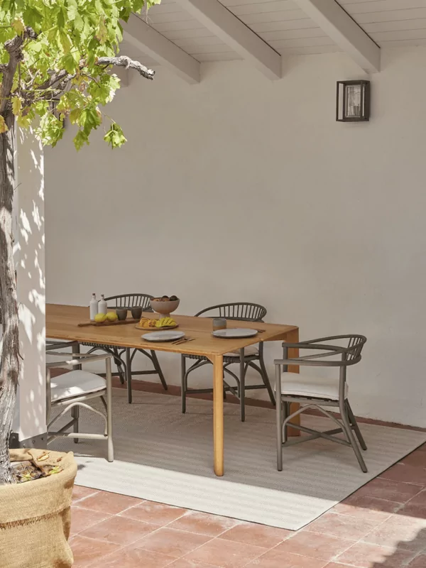 Fijn geweven visgraat patroon buiten vloerkleed onder patio met tafel en stoelen in beige
