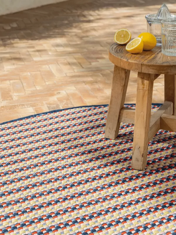 Buitenkleed sisal look met kleurencombinatie 3 in het rond met houten tafeltje met citroenen