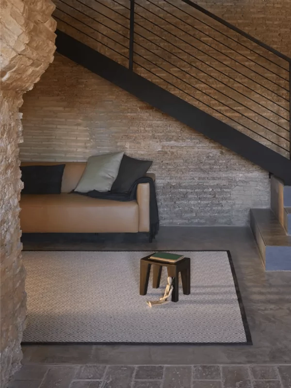 Fijn geweven buiten vloerkleed met diamant patroon met beige en zwarte accenten in house setting