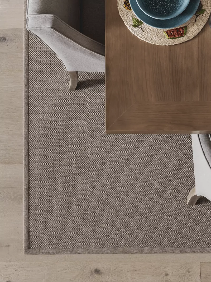 Fijn geweven buiten vloerkleed met zigzag patroon zand met eetkamertafel en stoelen